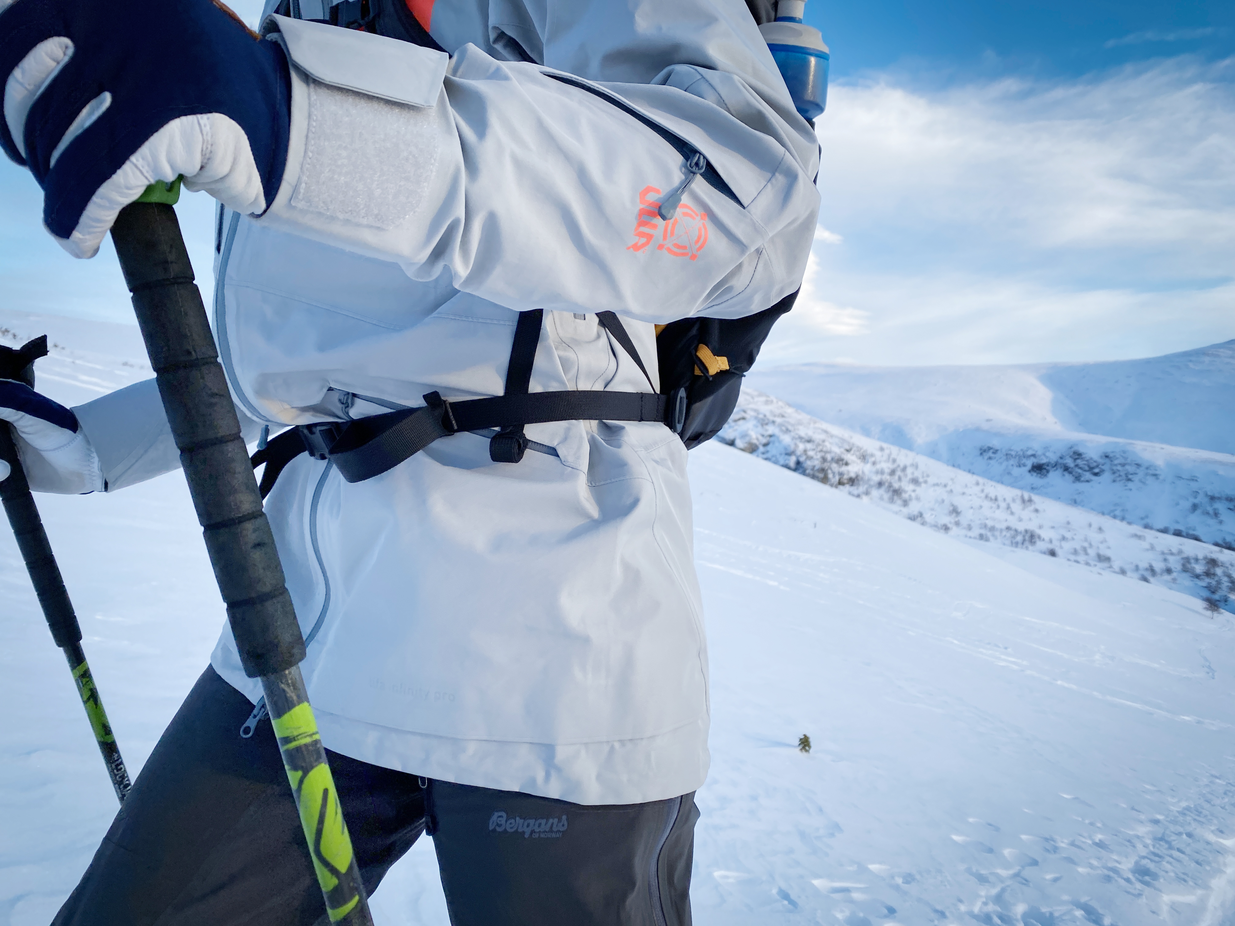 person med grå skalljakke på ski i vinterfjellet
