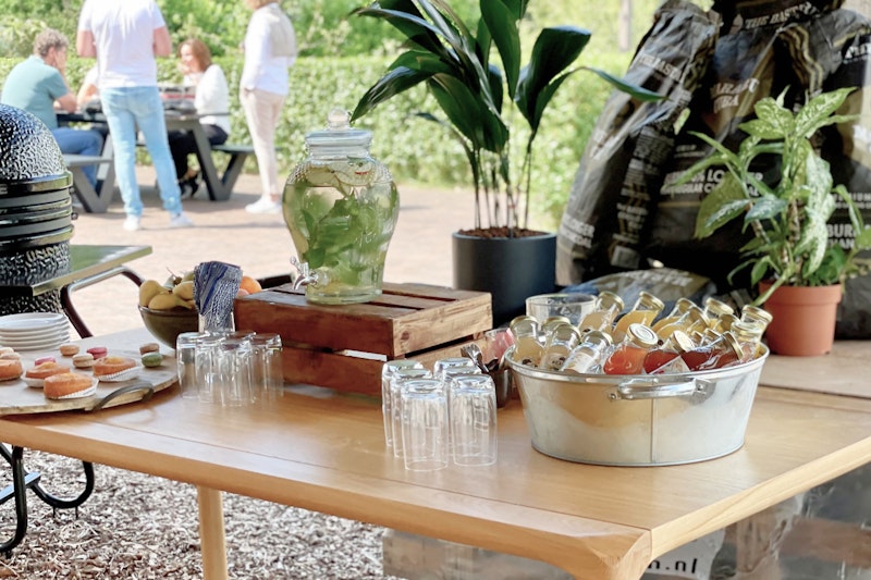 Tafel met flesjes sap op ijs, tap met muntwater en long-drink glazen