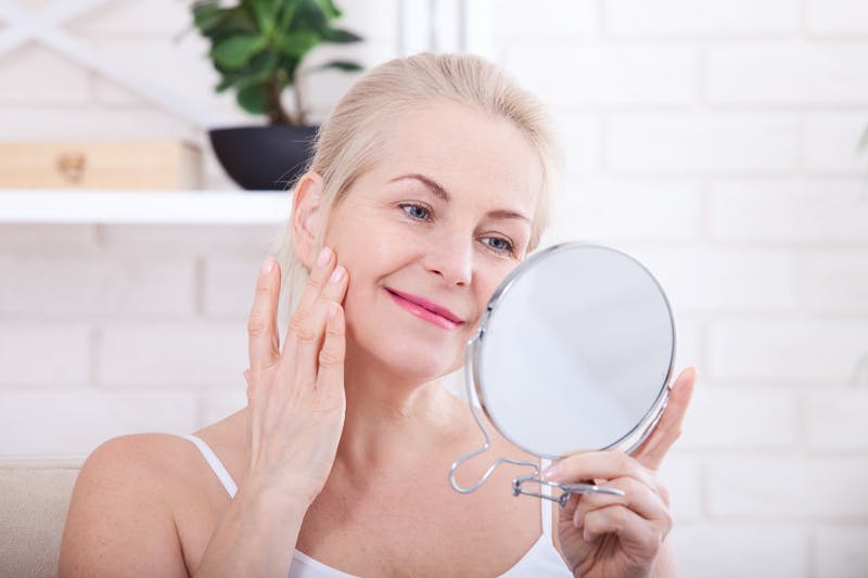 woman admiring her appearance in the mirror