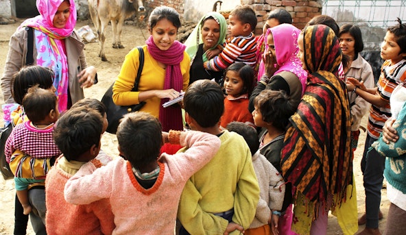Children surround female humanitarian worker