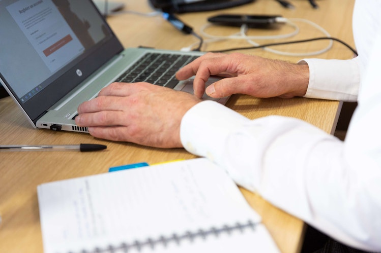 Hands typing on a laptop