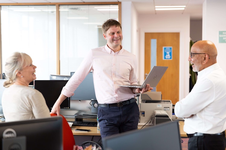 Three people having a casual meeting at Diversity Travel's office