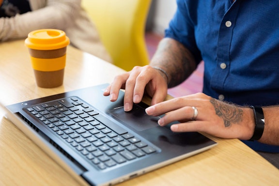 Male fingers typing on a laptop