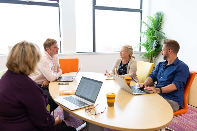 Een groep van vier accountmanagers in een kantoorvergadering