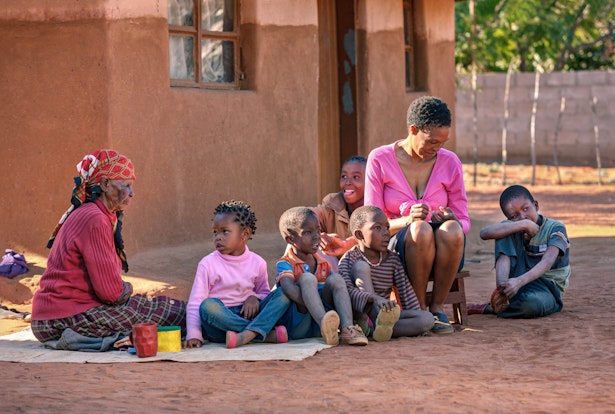 Famille assise à l'extérieur de la maison en Afrique