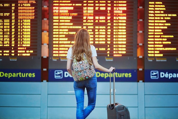 Girl at airport departure board