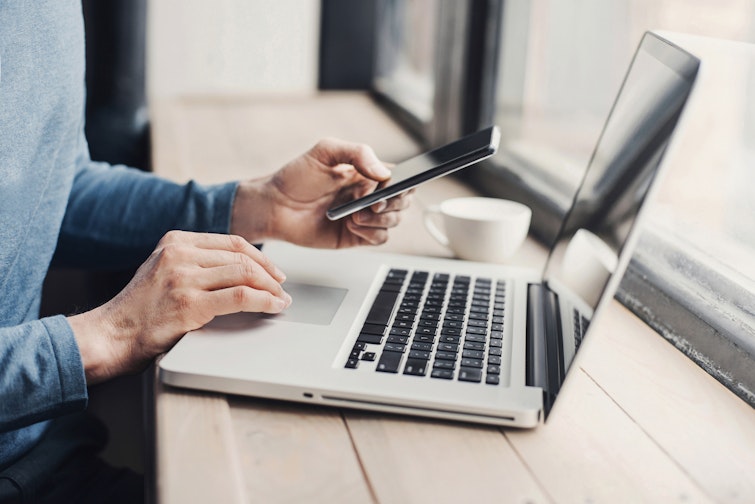 Person using laptop and phone