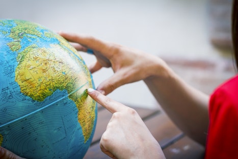 Girl pointing at globe