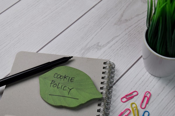 Politique relative aux cookies écrire sur une note collante isolée sur une table en bois.