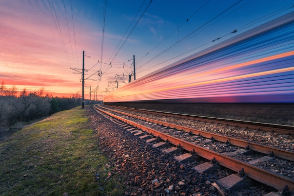 Trein die voorbij raast bij zonsondergang