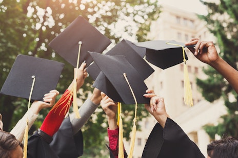 Students raising graduation caps