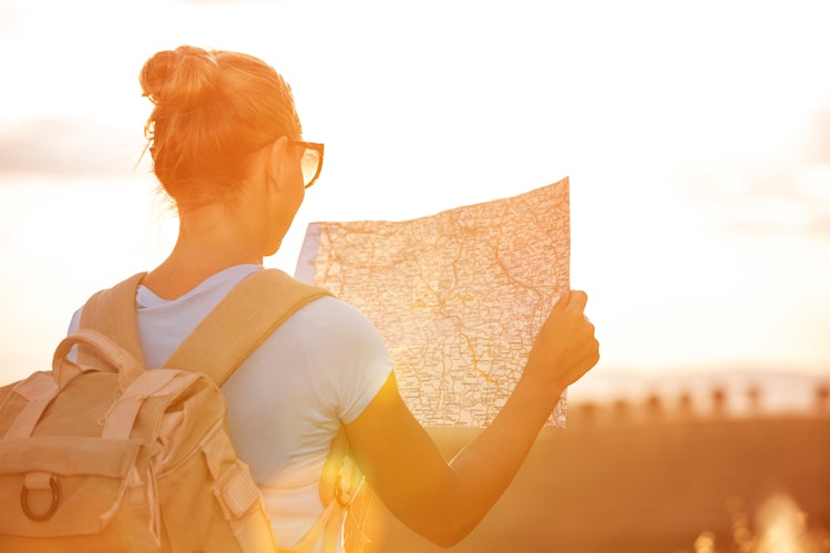 Vrouw leest een kaart in de zon