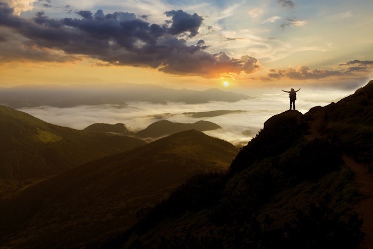 Hiker raising arms on top of mountain