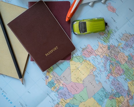 Passport pencil and other items on a map of the world