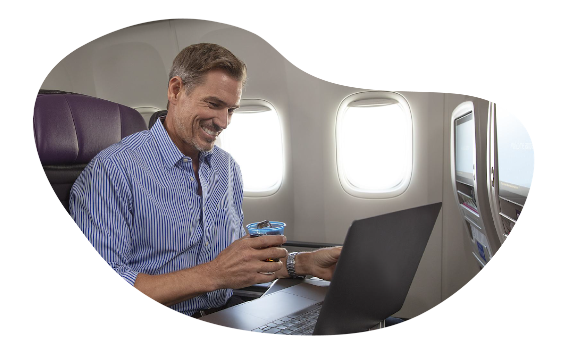 A man working on his laptop on a plane
