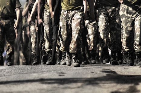 Military men walking towards a camera