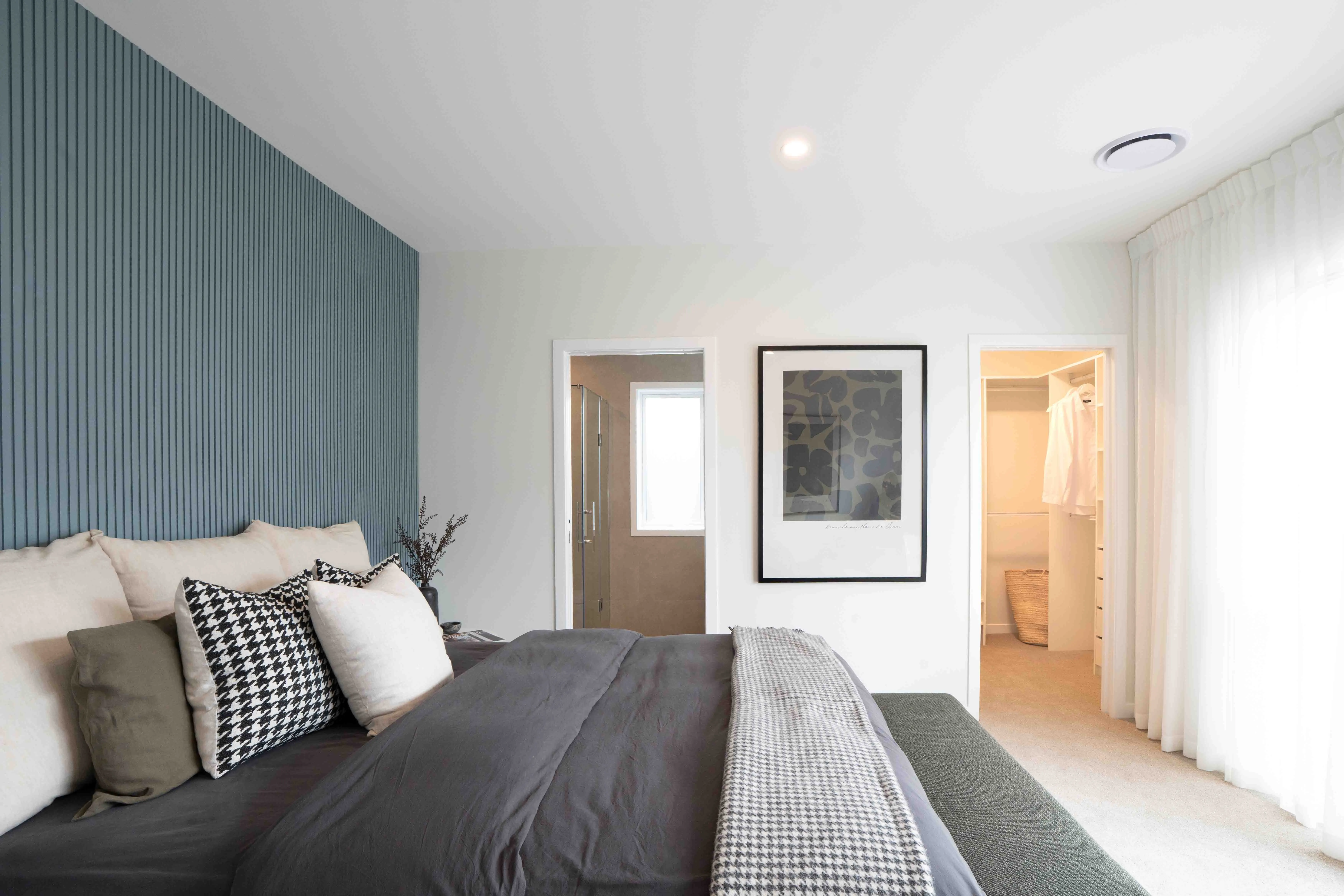 Milldale showhome master bedroom with feature wall, ensuite, and walk-in wardrobe