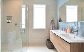 Family bathroom with blue tiles and wood grain vanity
