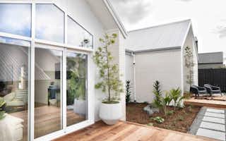 Pavilion style house design with white brick exterior