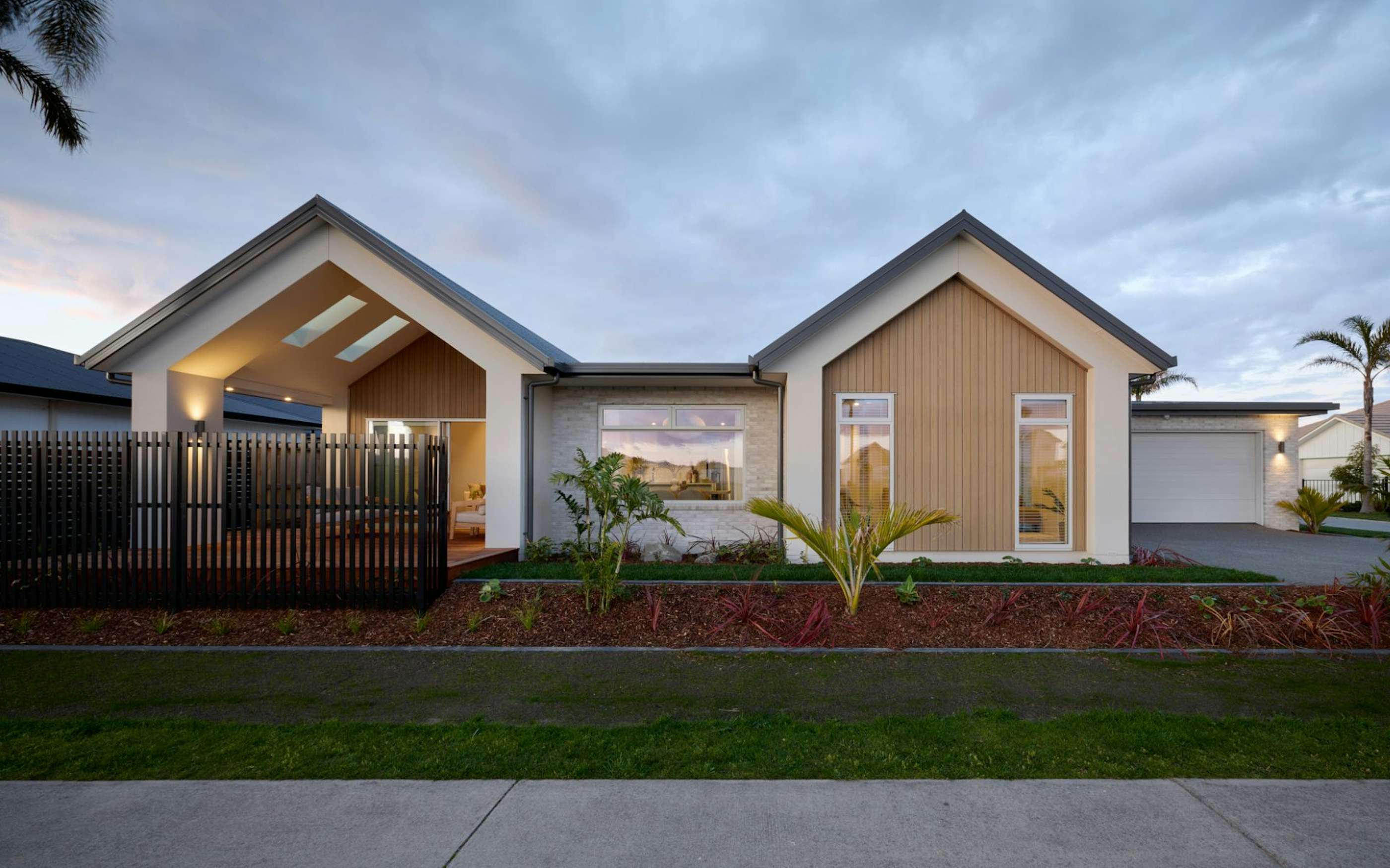 Contemporary house exterior in New Zealand with Scandinavian inspired design, timber and stone cladding, and family-friendly single level layout