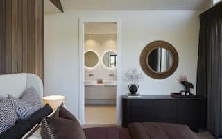 master bedroom design with ensuite. Warm browns and burgundy tone bedding and interiors.