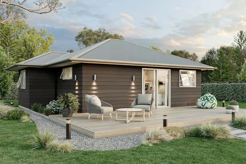 Two-bedroom minor dwelling exterior with timber deck, dark weatherboard cladding, and outdoor seating, designed by Signature Homes.