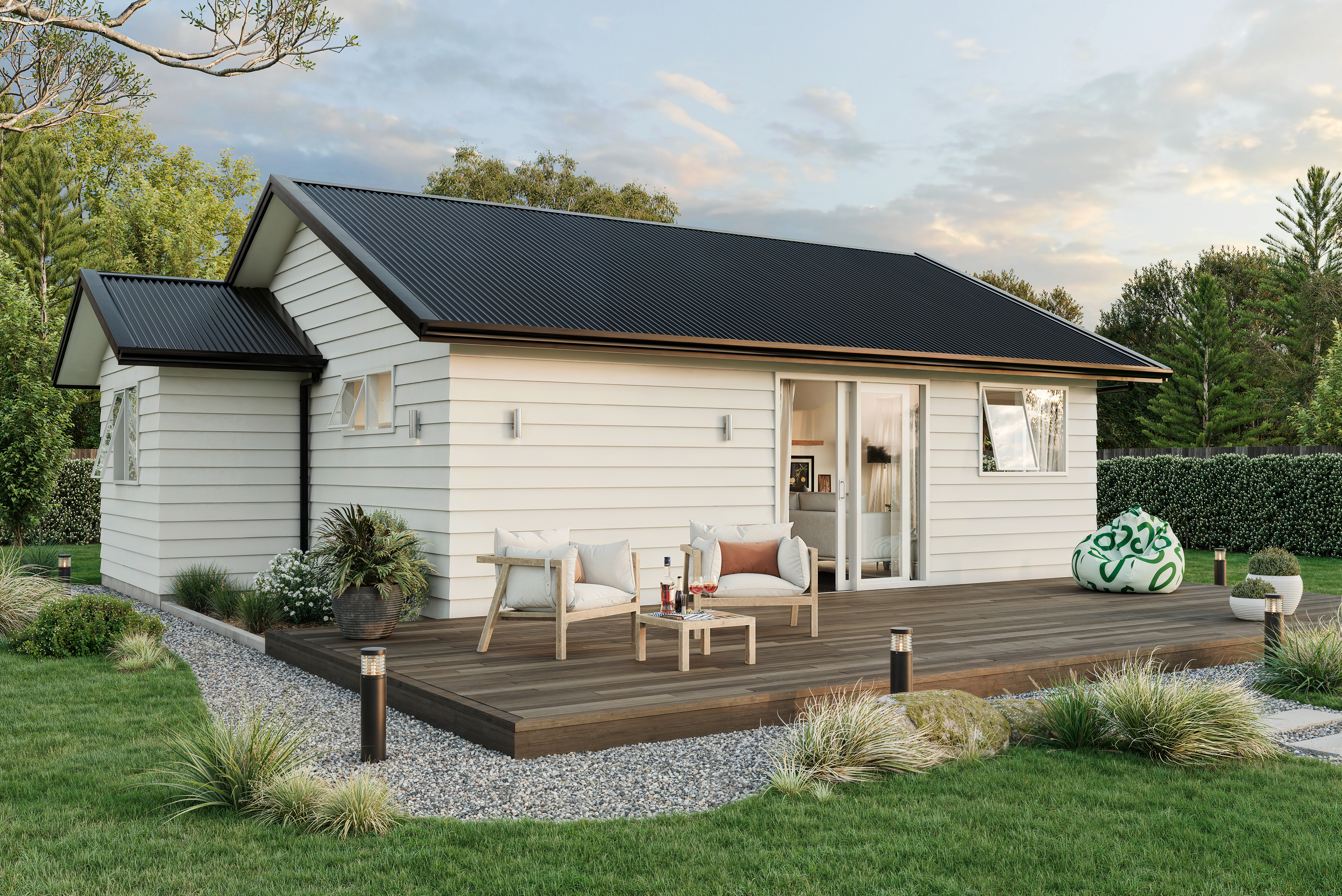 Two-bedroom minor dwelling exterior with timber deck, light weatherboard cladding, and outdoor seating, designed by Signature Homes.