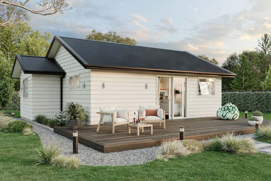 Two-bedroom minor dwelling exterior with timber deck, light weatherboard cladding, and outdoor seating, designed by Signature Homes.