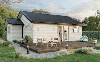 Two-bedroom minor dwelling exterior with timber deck, light weatherboard cladding, and outdoor seating, designed by Signature Homes.