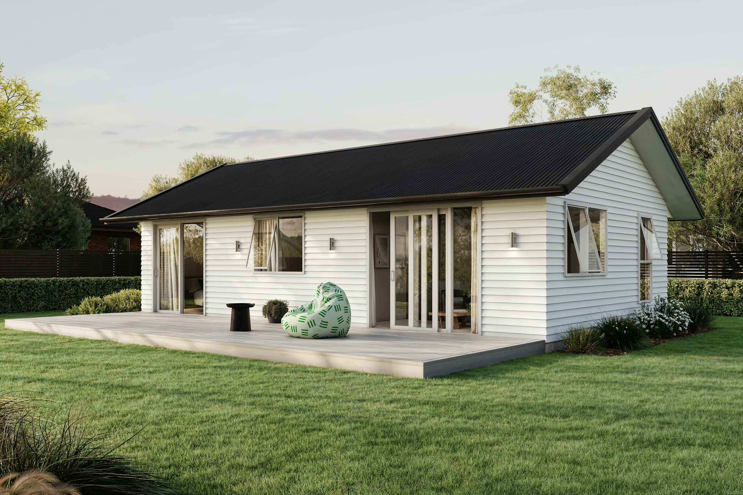 Signature Homes Minor Dwelling home with white weatherboard cladding, dark grey steel roof and light timber decking