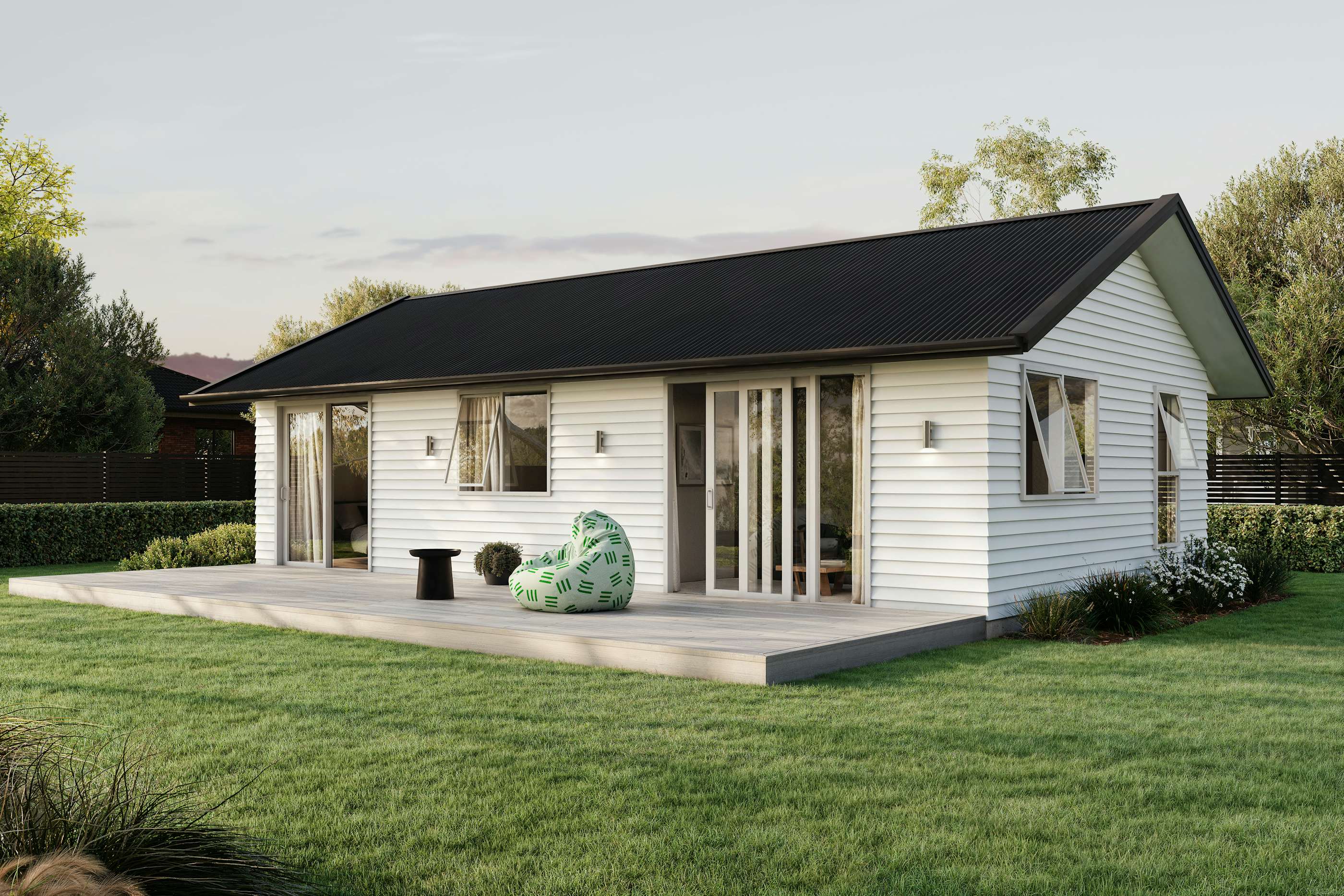 Signature Homes Minor Dwelling home with white weatherboard cladding, dark grey steel roof and light timber decking