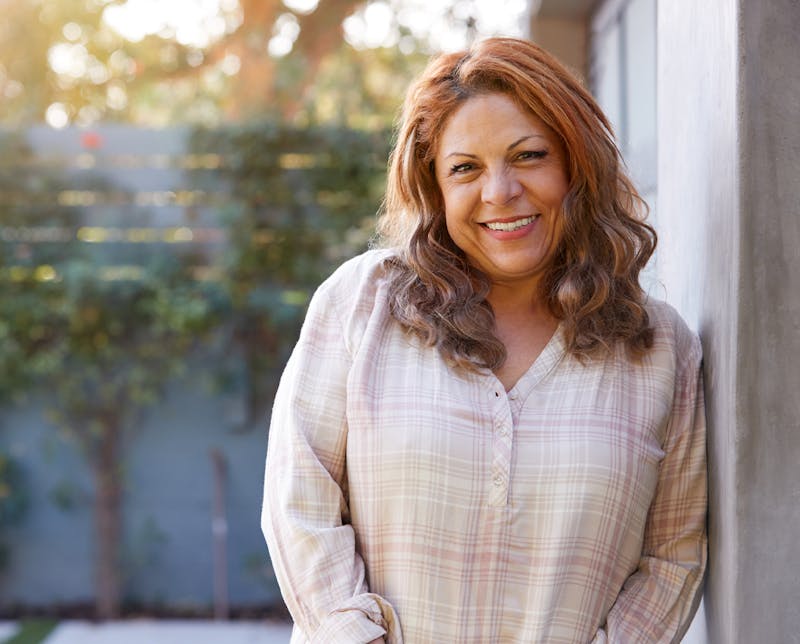 woman leaning against wall smiling