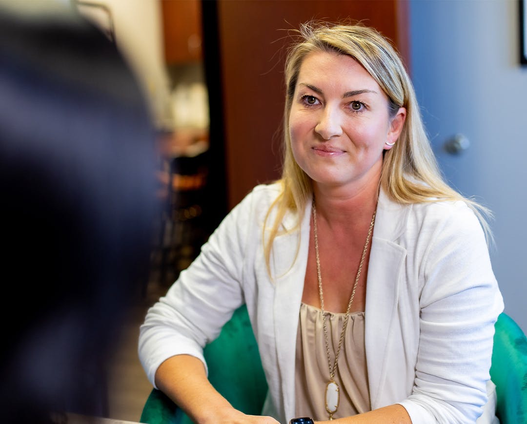 woma siting in a green chair smiling at someone else