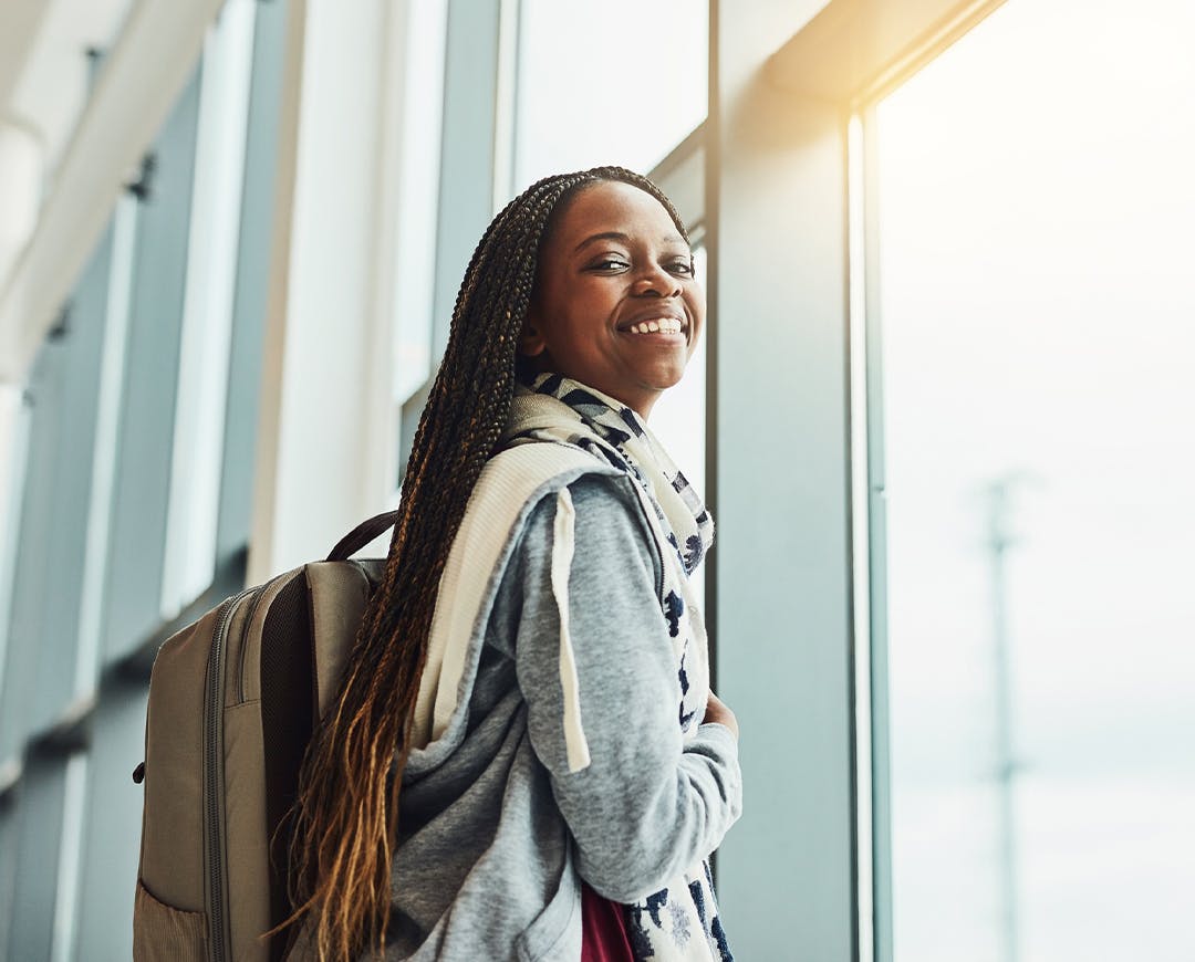 woman standing next to a window smiling