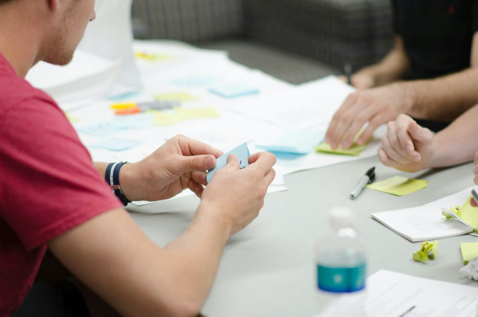 People at a desk writing post it notes