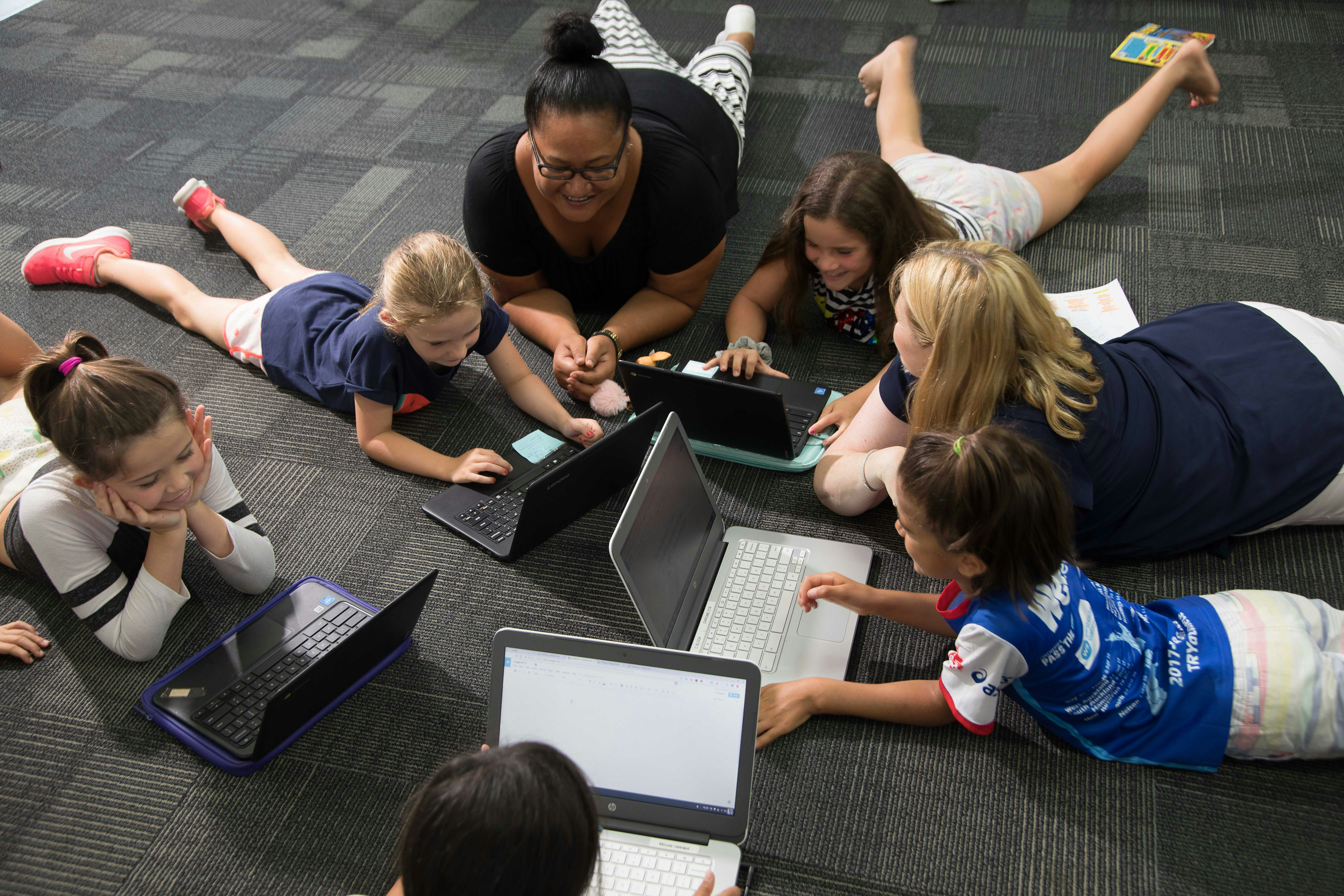Teachers and students working in a group on the floor