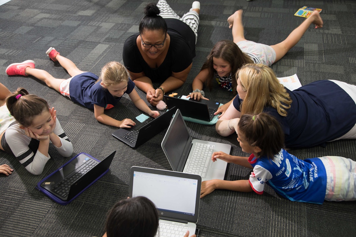 Teachers and students working in a group on the floor