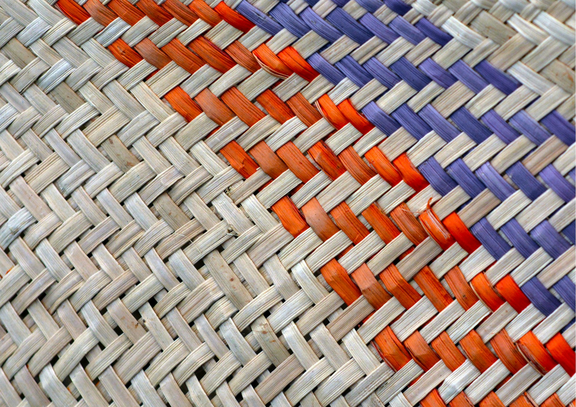 Woven kete with orange and blue flax
