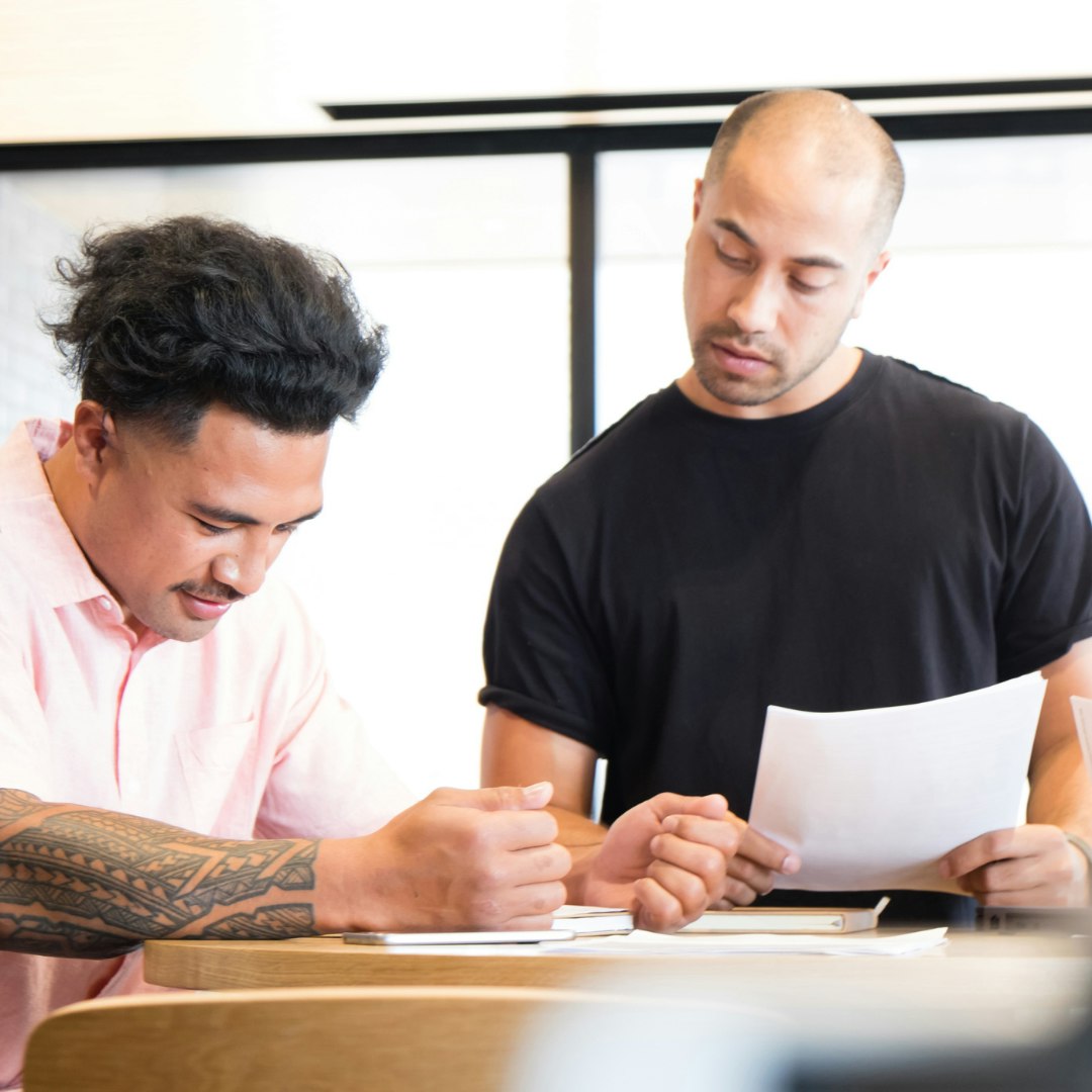 Two men looking at the same piece of paper