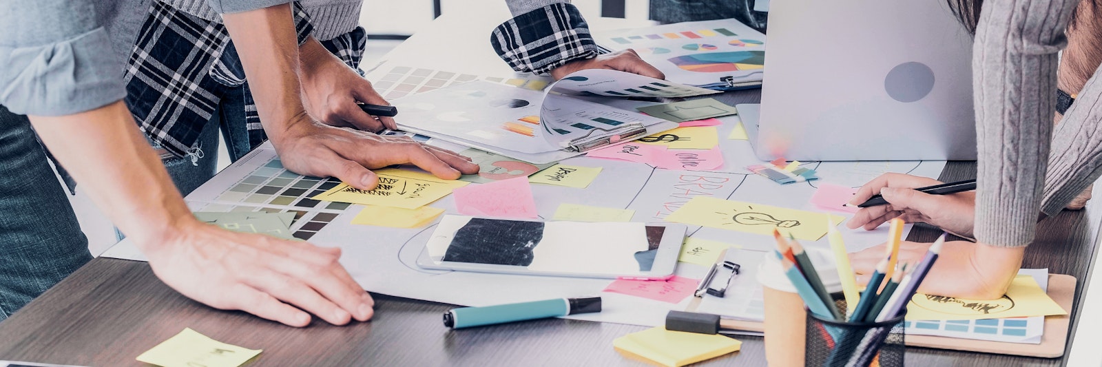 Group of people looking at charts, post-its, and written notes