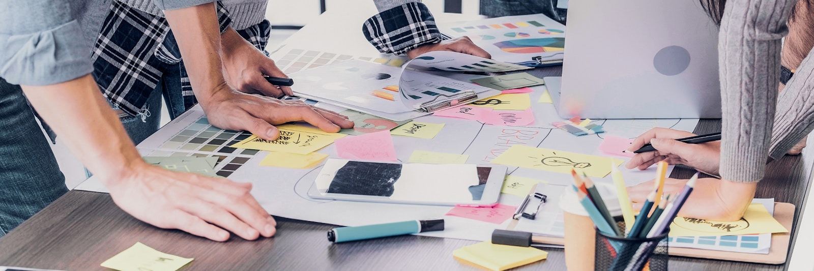 Group of people looking at charts, post-its, and written notes