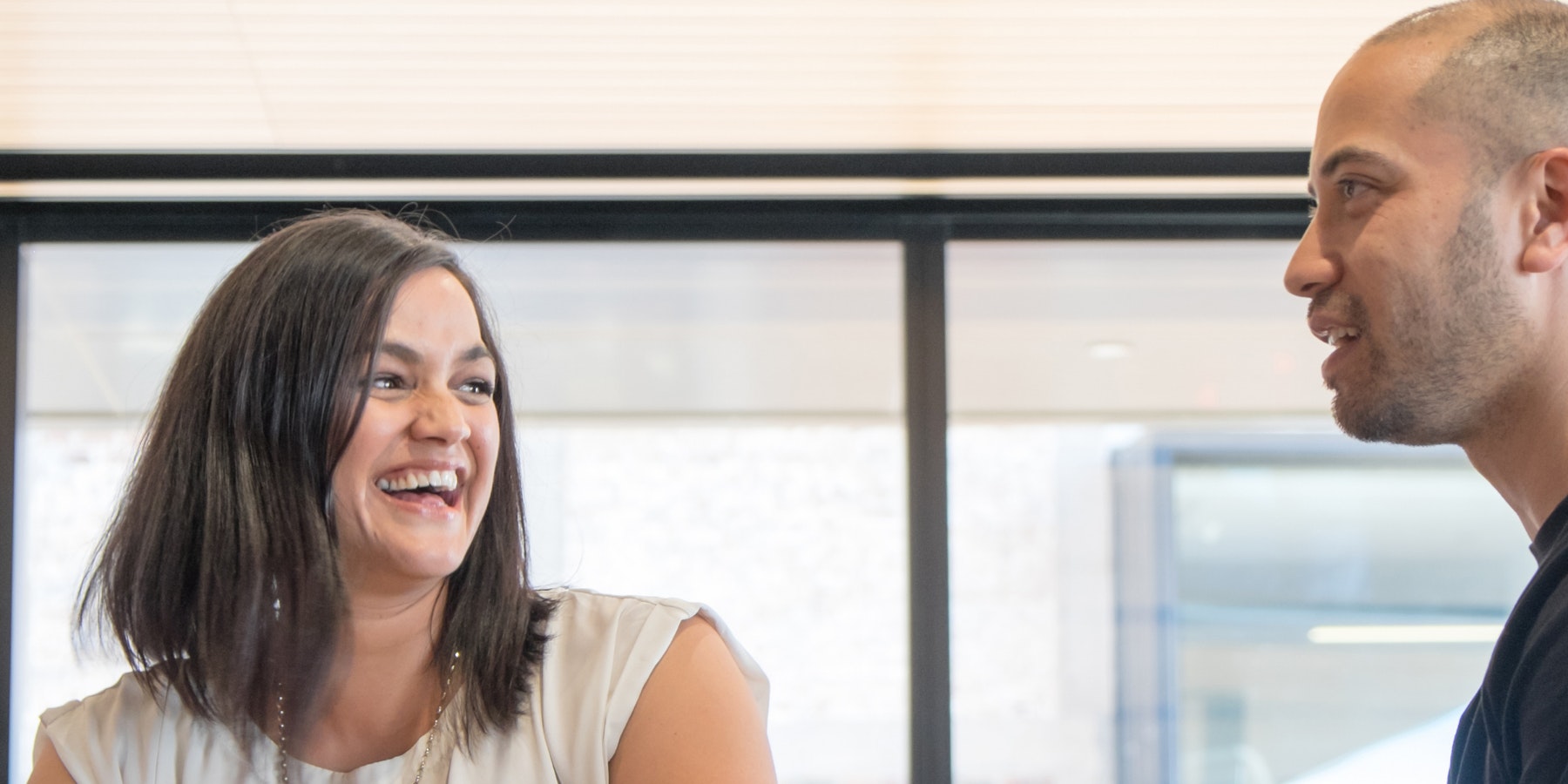 A man and woman laughing in an office