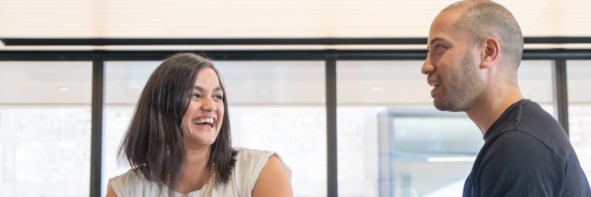 A man and woman laughing in an office