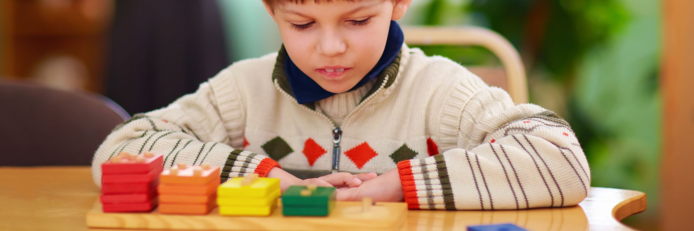 A child looking at coloured blocks