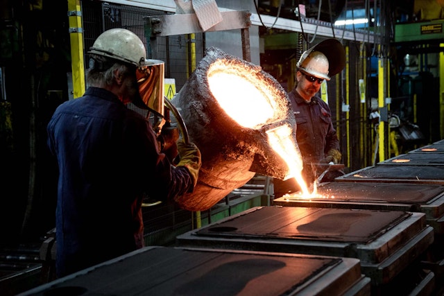 Medarbetare häller smält metall i formar i en industriell gjuterimiljö.