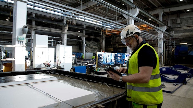 Industrimedarbetare går igenom checklista i Boards on Fire på surfplatta.