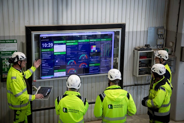 Team följer upp produktion på en digital Boards on Fire-tavla.