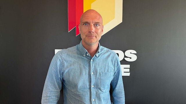 Person står framför Boards on Fire-logotypen på en mörk kontorsvägg