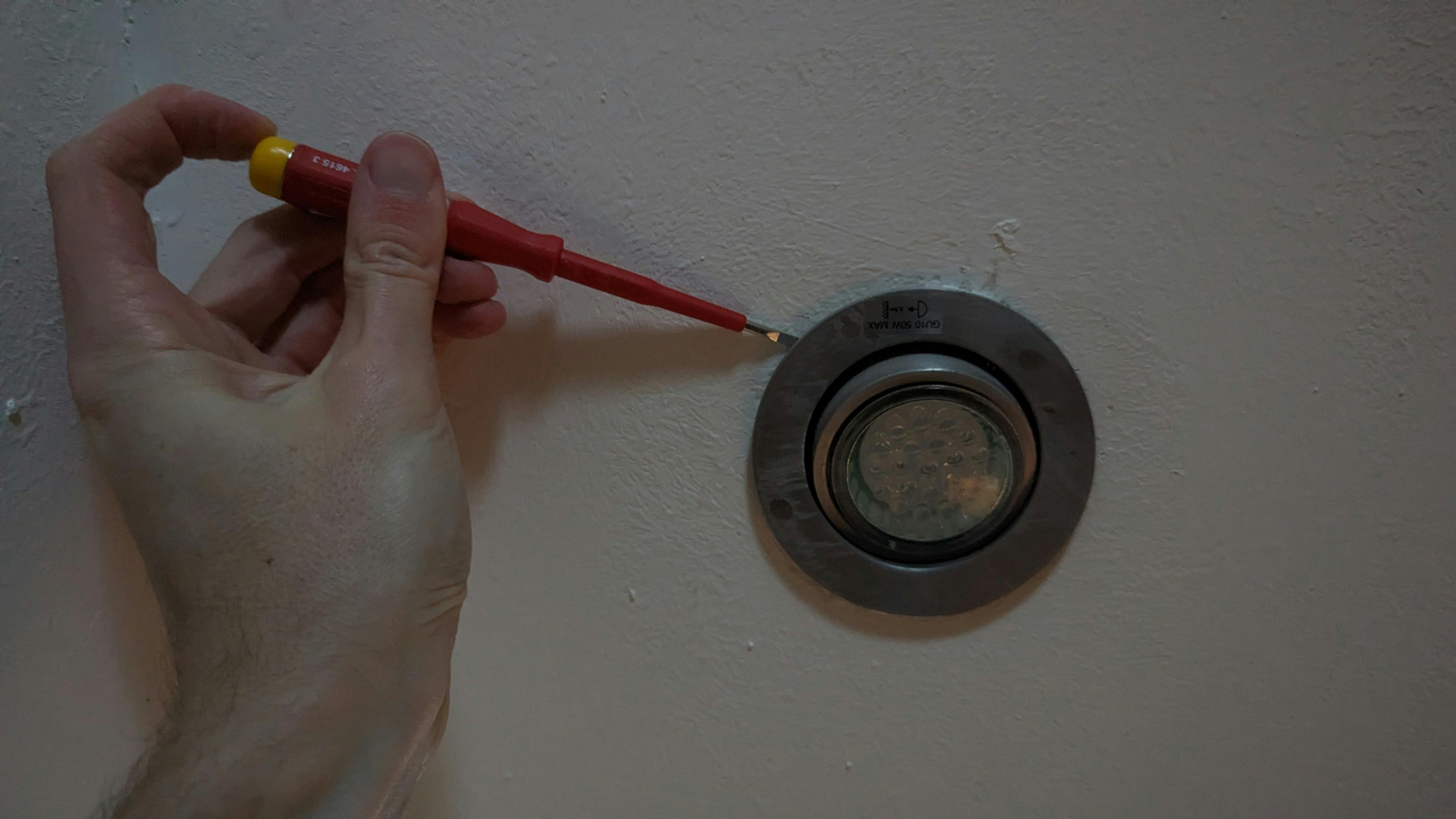 Met een schroevendraaiertje haal je een inbouwspot gemakkelijk van het plafond.