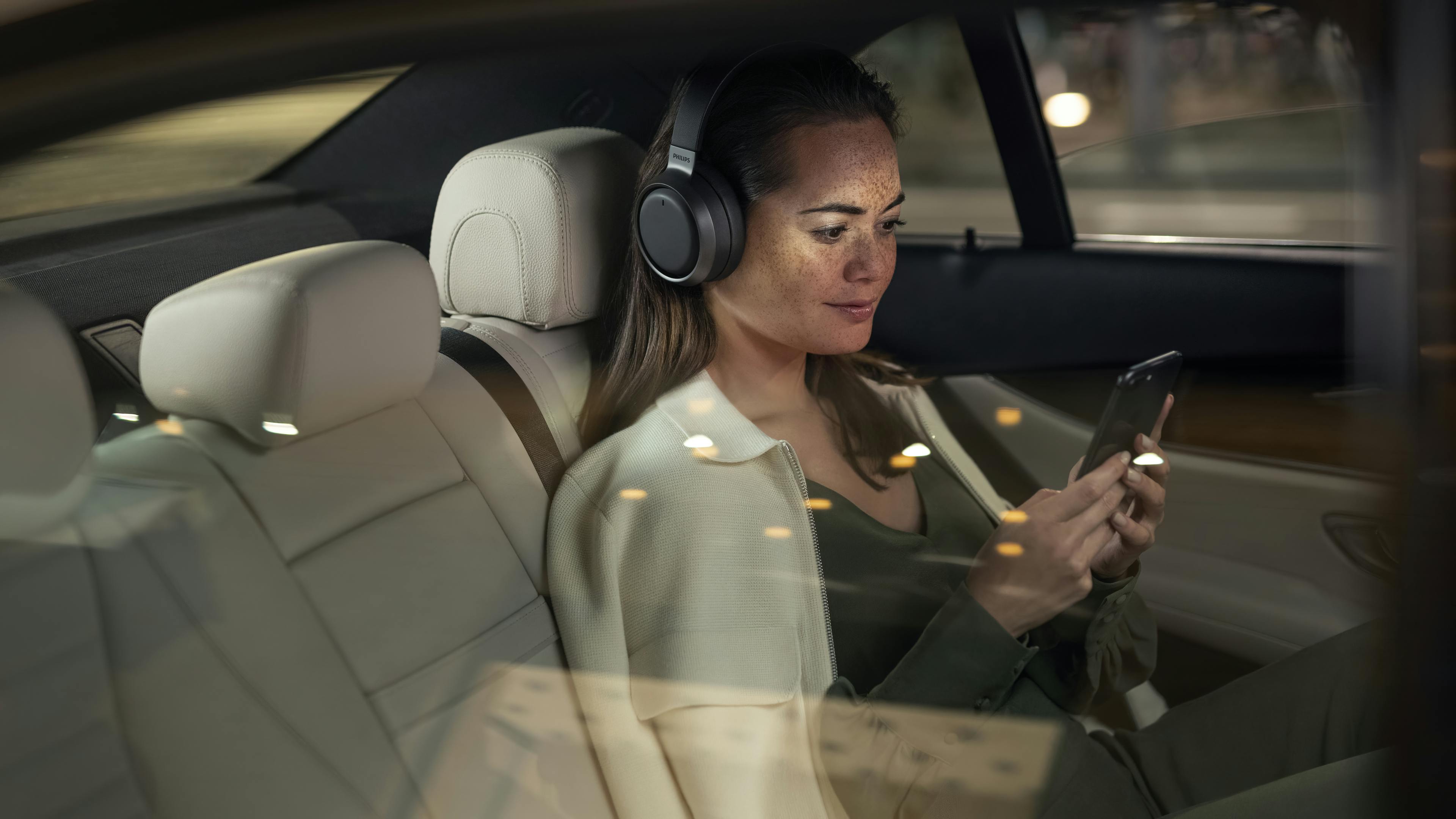 Over-ears koptelefoon gedragen in de auto.